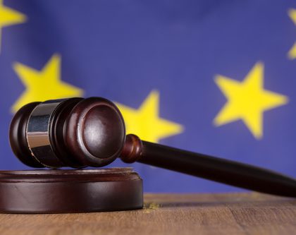 an image of European Union flag and a gavel on a wooden desk in front