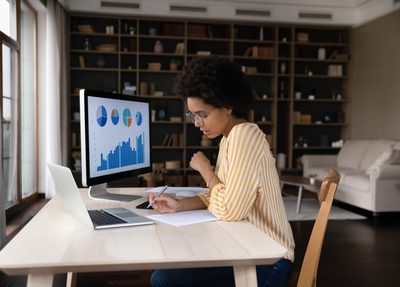 woman sitting at computer desks analyzing data