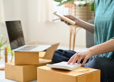 woman with a calculator, laptop and packages