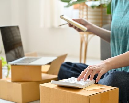 woman with a calculator, laptop and packages