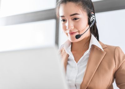 smiling woman with headset and laptop