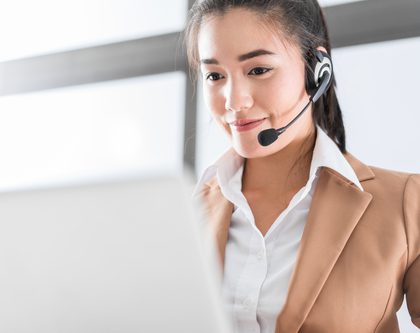 smiling woman with headset and laptop