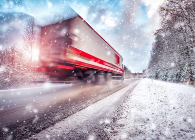 semi truck driving on snowy highway