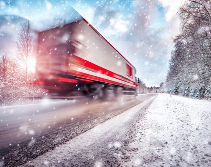 semi truck driving on snowy highway