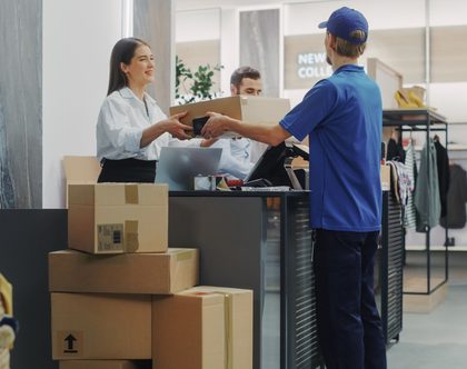 woman handing over package at shipping carrier counter