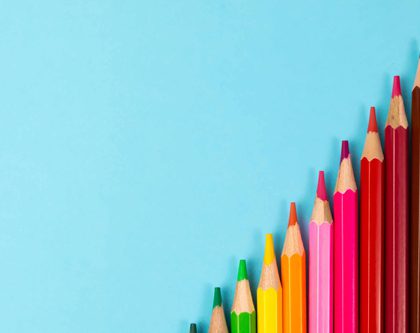 a row of colorful wooden pencils on a blue background for kids going back to school