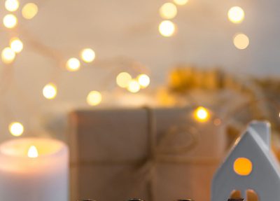 image with a wrapped gift, candles, string lights and a 2024 plaque