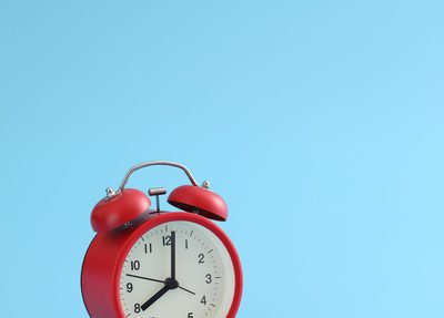 red alarm clock with blue background