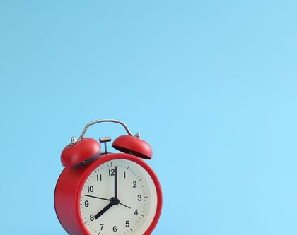 red alarm clock with blue background