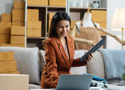 Woman sitting at a desk with clipboard and laptop