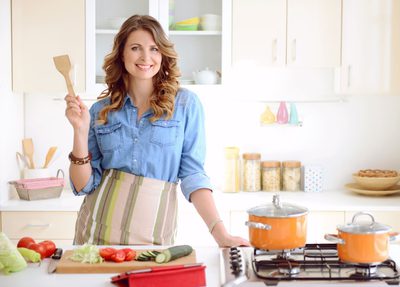 A woman standing and cooking in the kitchen