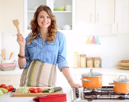 A woman standing and cooking in the kitchen