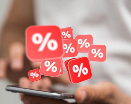 a person holding a phone with discount symbols popping up