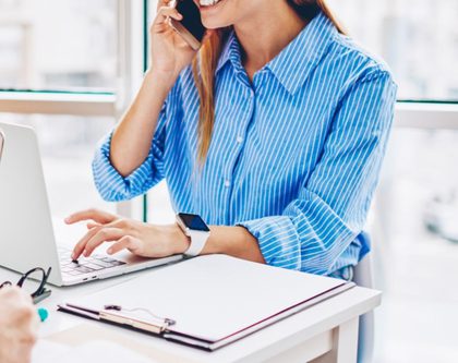 woman sitting at a desk on the phone