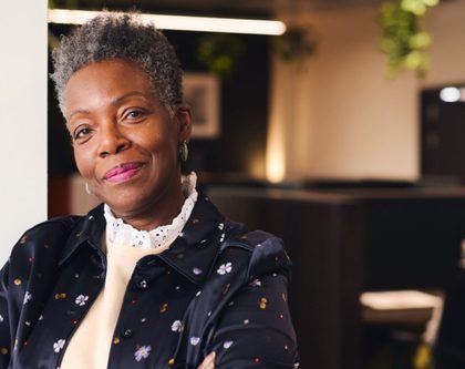 smiling black woman with arms crossed in an office setting