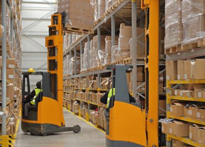 fork lifts picking up boxes in a warehouse