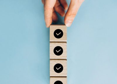 a person holds a wooden blocks with check mars