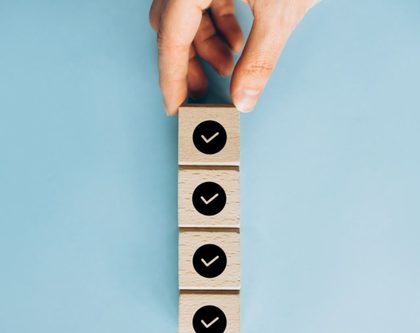 a person holds a wooden blocks with check mars