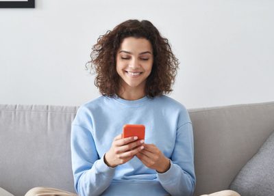 a woman sitting on a couch on her phone