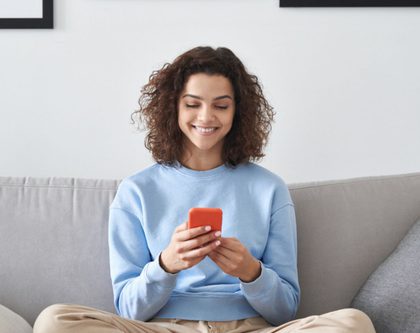a woman sitting on a couch on her phone