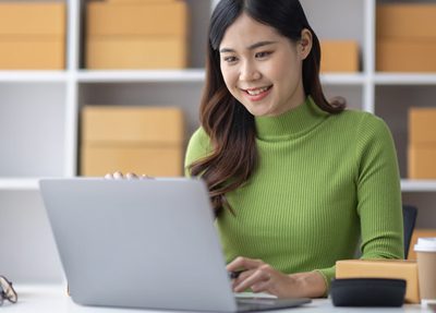 woman smiling typing on laptop