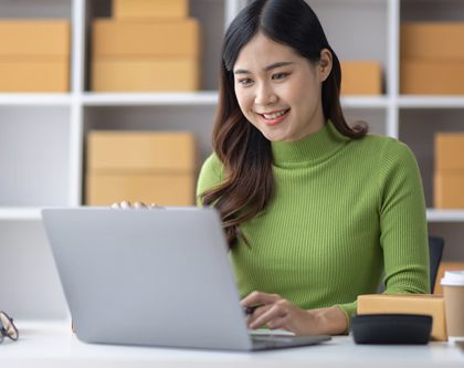 woman smiling typing on laptop