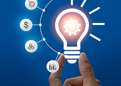 a hand holds a light bulb surrounded by various icons