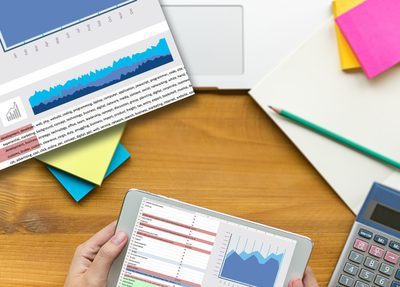 hands holding tablet displaying a data and a graph
