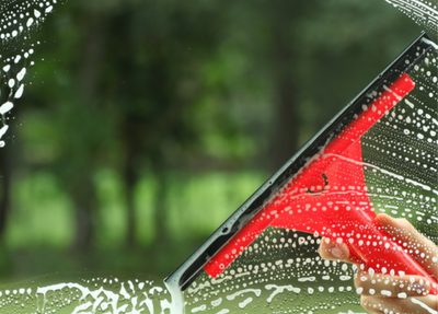 window getting cleaned with squeegee