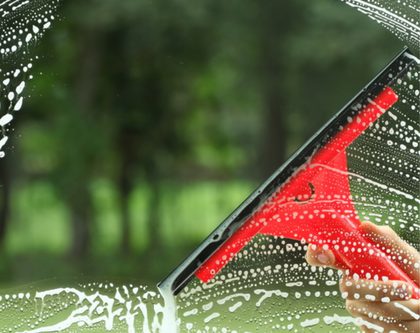 window getting cleaned with squeegee