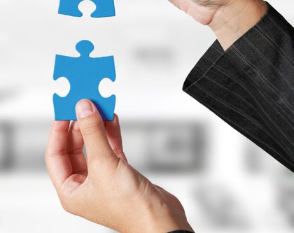 two hands holding blue puzzle pieces