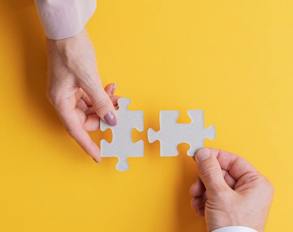 Two hands holding matching puzzle pieces