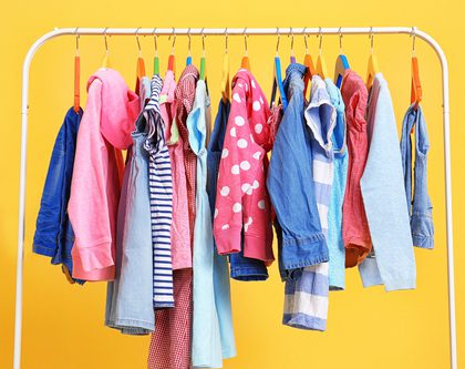 A clothing rack with colorful apparel on a yellow background