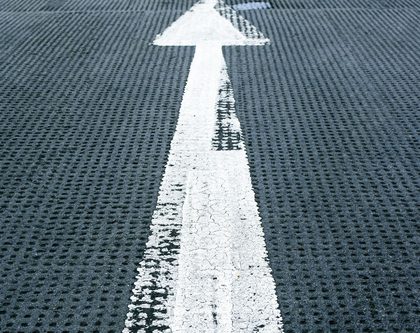An arrow sign on the street ground