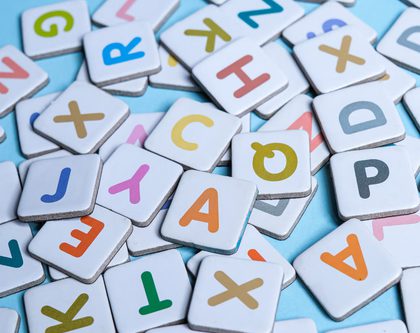 A collection of alphabet letters on white cards on a blue floor for Amazon Strategies