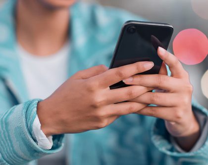 A girl using a mobile phone to scroll on social media for Amazon products
