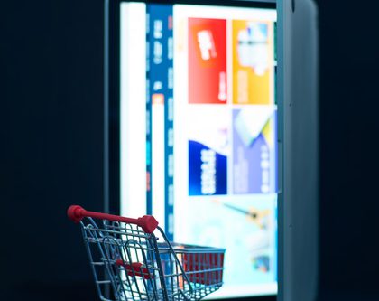 A shopping cart in front of a laptop digital shelf