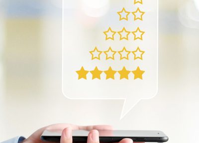 hand holding a mobile phone with review rating stars