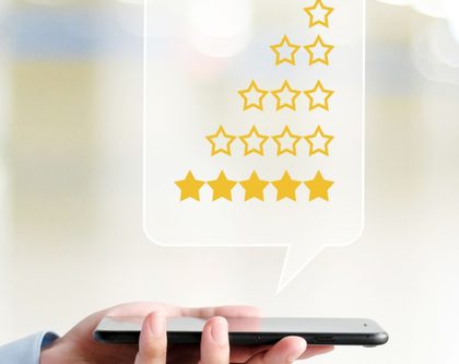 hand holding a mobile phone with review rating stars