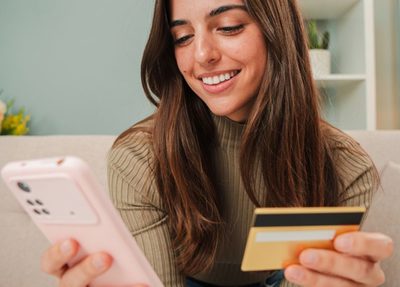 a woman shopping online uses her credit card to check out