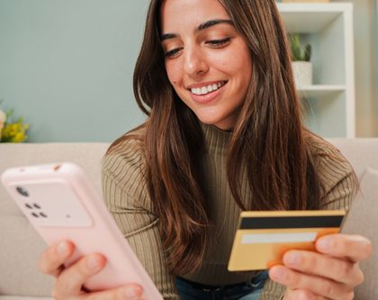 a woman shopping online uses her credit card to check out