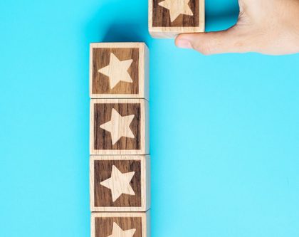 a person holds wooden blocks decorated with stars