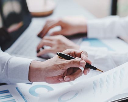 business professionals collaborating on a document at a desk