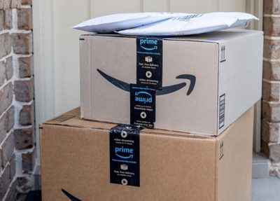 Amazon prime package stacked up in front of a residential home