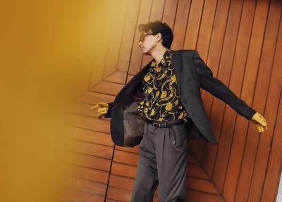 Man in yellow and black floral shirt dancing