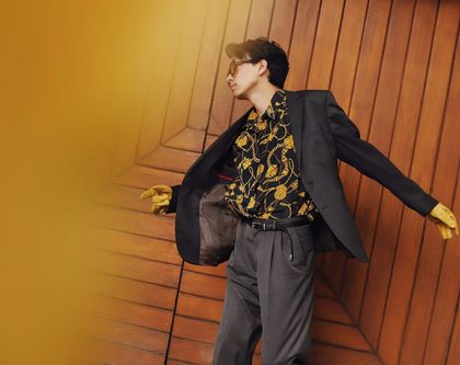 Man in yellow and black floral shirt dancing